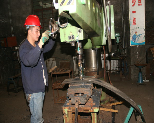 职工在利用废旧皮带加工W钢带.jpg